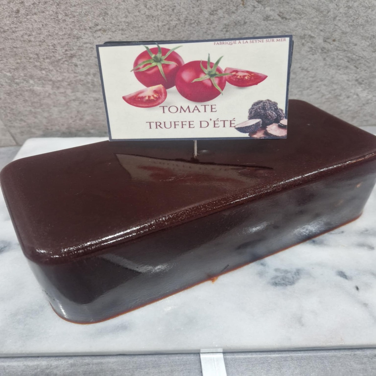 Pâte De Fruit Tomate Truffe D’été Pâtes de fruits Qualité Artisanale Pâte de fruit artisanale à la tomate et truffe d'été, présentée en cubes délicatement texturés pour une dégustation authentique.