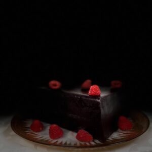 Gros plan sur une pâte de fruit à la framboise artisanale, aux teintes rouge profondes, révélant une texture moelleuse.