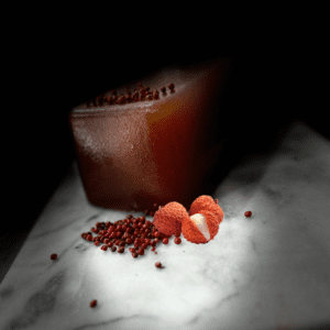 Gros plan sur la pâte de fruit litchi baies roses, mettant en valeur sa texture moelleuse et sa teinte délicate, prête à être dégustée.